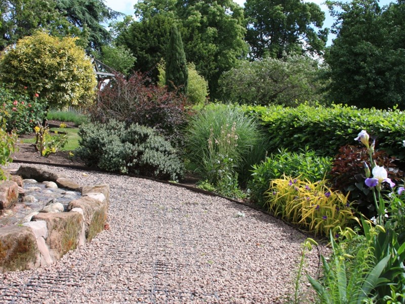 Gravel path with stream running alongside, ornamental and fragrant bedding